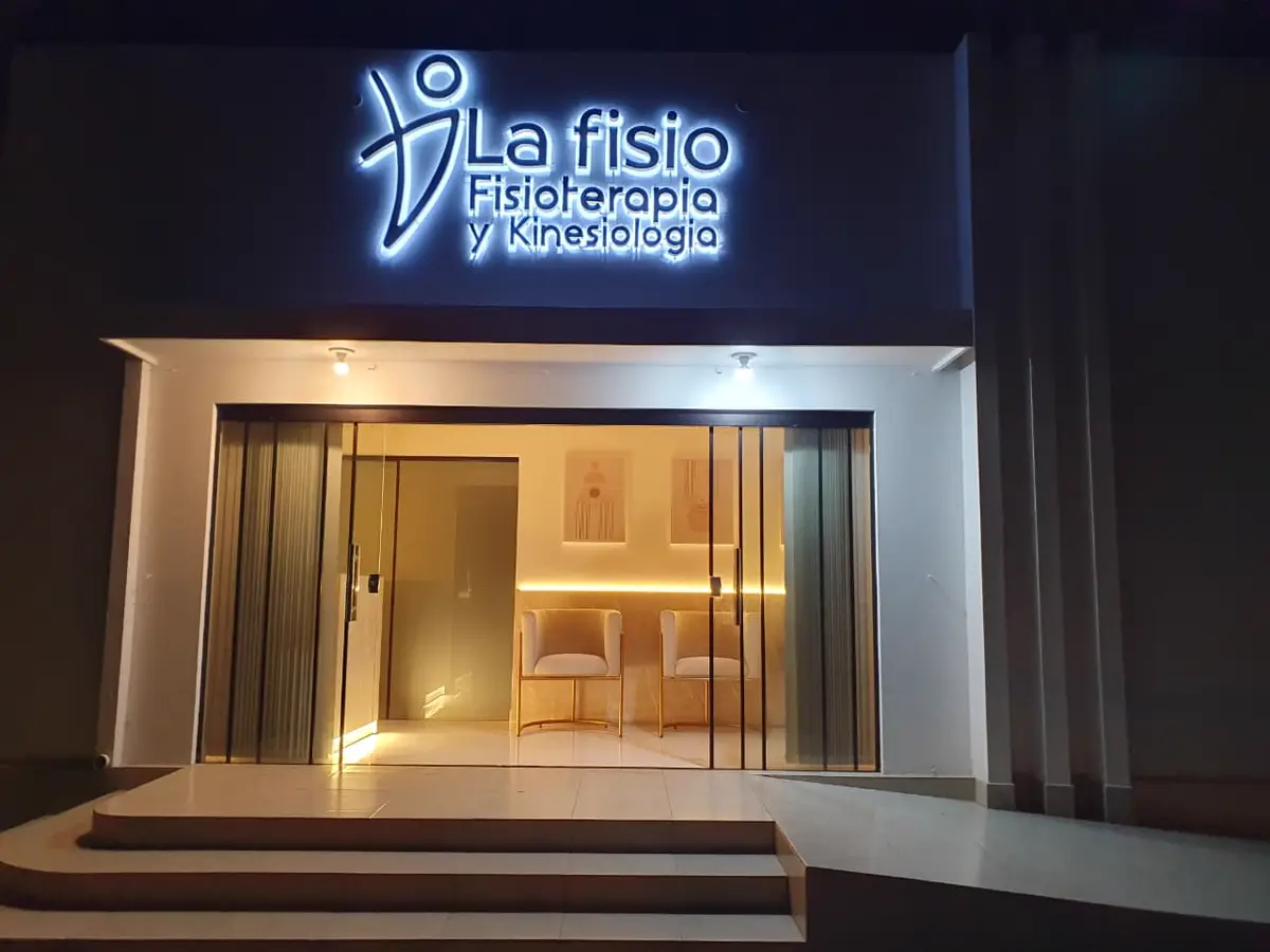 Fachada iluminada de La Fisio en horario nocturno.